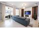 Bright living area with modern sofa, sleek fireplace, and sliding glass doors to a patio at 16061 Blue Wave Way, Clermont, FL 34714