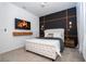 Modern primary bedroom with a dark accent wall, mounted TV, and plush furnishings at 16061 Blue Wave Way, Clermont, FL 34714