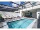 Backyard featuring a screened-in pool, patio seating, and relaxing lounge chairs for outdoor enjoyment at 16061 Blue Wave Way, Clermont, FL 34714