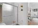 Cozy bathroom with a walk-in shower featuring white tile and a glass door at 16120 Bristol Lake Cir, Orlando, FL 32828