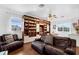 Spacious living room featuring custom bookshelves, sleek floors, and a cozy leather sofa at 16120 Bristol Lake Cir, Orlando, FL 32828