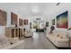 Bright living room featuring white furniture, gray wood floors, and artistic decor leading to an outdoor pool area at 16120 Bristol Lake Cir, Orlando, FL 32828