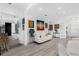 Spacious living room with art, white sofas, and grey hardwood floors, leading to other rooms at 16120 Bristol Lake Cir, Orlando, FL 32828