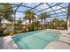 Inviting screened-in pool area with tropical landscaping, a hot tub, and a tranquil lake view at 16120 Bristol Lake Cir, Orlando, FL 32828