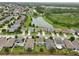 A picturesque aerial view of a residential neighborhood with a scenic lake and lush green spaces at 16440 Centipede St, Clermont, FL 34714