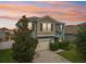 Two story home with a beige two-car garage, manicured landscaping, and a decorative tree in the front lawn at 16440 Centipede St, Clermont, FL 34714