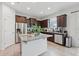 Bright kitchen with a granite island, dark wood cabinets, stainless steel appliances and tile flooring at 16440 Centipede St, Clermont, FL 34714