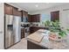 Bright kitchen with a granite island, dark wood cabinets, stainless steel appliances and tile flooring at 16440 Centipede St, Clermont, FL 34714