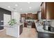 Bright kitchen with a granite island, dark wood cabinets, stainless steel appliances and tile flooring at 16440 Centipede St, Clermont, FL 34714