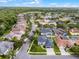 Aerial view of a community with homes, green spaces, and a distant view of some industrial structures at 201 Hammock Dunes Pl, Orlando, FL 32828