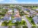 Aerial view of a suburban neighborhood with mature trees, landscaped yards, and a lake at 201 Hammock Dunes Pl, Orlando, FL 32828