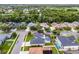Aerial view of a green house in a neighborhood, highlighting its screened pool and lush landscaping at 201 Hammock Dunes Pl, Orlando, FL 32828