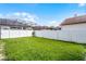 This spacious backyard is surrounded by a white fence and has a view of the screened-in pool at 201 Hammock Dunes Pl, Orlando, FL 32828