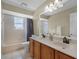 Bright bathroom featuring a double sink vanity, a mirror, and a shower/tub combo offering both functionality and style at 201 Hammock Dunes Pl, Orlando, FL 32828