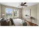 Bright bedroom featuring two large windows, neutral walls, wood floors, and modern decor with green accents at 201 Hammock Dunes Pl, Orlando, FL 32828