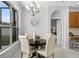 Bright dining area features a stylish chandelier, a decorative clock, and access to a bedroom at 201 Hammock Dunes Pl, Orlando, FL 32828
