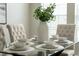 Dining area with glass-top table, white chairs, and a view of the window at 201 Hammock Dunes Pl, Orlando, FL 32828