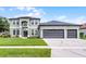 Charming two-story home featuring a three-car garage and well-manicured lawn at 201 Hammock Dunes Pl, Orlando, FL 32828