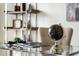 Desk detail with globe and books atop a chrome desk with a shelving unit in the background at 201 Hammock Dunes Pl, Orlando, FL 32828