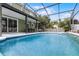 The screened-in pool in backyard is surrounded by patio with a dining area at 201 Hammock Dunes Pl, Orlando, FL 32828
