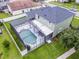 A green two-story home featuring a screened-in pool area and a well-manicured lawn at 201 Hammock Dunes Pl, Orlando, FL 32828