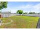 Spacious backyard with green grass, a privacy fence, a shed, and a circular brick feature at 2017 W Gore St, Orlando, FL 32805