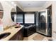 Contemporary bathroom with black tile, jacuzzi tub, separate shower, and double vanity with granite countertop at 2017 W Gore St, Orlando, FL 32805