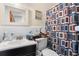 This bathroom features tile walls and a framed mirror over vanity, complemented by a shower with colorful, patterned curtain at 2044 W Gore St, Orlando, FL 32805