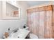 Bathroom features white tile walls and a vanity with a framed mirror, along with a shower with patterned curtain at 2044 W Gore St, Orlando, FL 32805