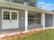 Attractive front porch with white columns, double doors, and stone walkway, enhanced by colorful landscaping at 2050 Anne Cir, South Daytona, FL 32119