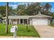 Well-maintained home featuring a mailbox and green lawn, complemented by a paved driveway and garage at 2050 Anne Cir, South Daytona, FL 32119