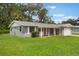 Charming single-story home with a gray exterior, white trim, and a spacious front yard with mature trees at 2050 Anne Cir, South Daytona, FL 32119
