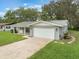 Exterior home view highlighting the attached garage, neutral paint, and paved driveway at 2050 Anne Cir, South Daytona, FL 32119
