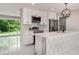 Modern kitchen with white cabinets, stainless steel appliances, quartz countertops, and stylish lighting at 2050 Anne Cir, South Daytona, FL 32119