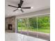 Cozy living room with brick fireplace, sliding glass doors to the patio, and modern ceiling fan at 2050 Anne Cir, South Daytona, FL 32119
