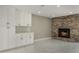 Open-concept living area showcasing a brick fireplace, marble floors, and modern white cabinets at 2050 Anne Cir, South Daytona, FL 32119