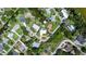An aerial view showcasing a neighborhood, lush greenery and mature trees with a home nestled along the waterway at 225 Temple Cir, Eustis, FL 32726