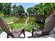 Tranquil backyard featuring outdoor seating, lush landscaping, and serene views of the peaceful canal with private docks at 225 Temple Cir, Eustis, FL 32726