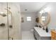 Modern bathroom featuring glass-enclosed shower, updated fixtures, and stylish vanity with round mirror at 225 Temple Cir, Eustis, FL 32726