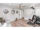Bright bedroom boasts wood floors, modern ceiling fan, and natural light from door to hall at 225 Temple Cir, Eustis, FL 32726