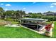 Waterfront property showcasing a covered boat dock with boat, tropical landscaping, and green grass at 225 Temple Cir, Eustis, FL 32726