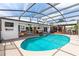 Beautiful screened-in pool area, showcasing the pool, comfortable seating, covered bar area, perfect for outdoor entertainment and relaxation at 225 Temple Cir, Eustis, FL 32726