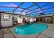 Expansive screened-in pool area with an inviting pool and a covered bar area, perfect for entertaining and relaxation at 225 Temple Cir, Eustis, FL 32726