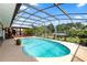 Stunning screened-in pool area featuring a beautiful pool, a covered bar, lush landscaping and seating, for the ultimate outdoor enjoyment at 225 Temple Cir, Eustis, FL 32726