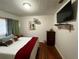 Bedroom with TV, fan, side tables, wood floors, and colorful bed and pillows at 2429 S Laurel Ave, Sanford, FL 32771