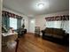 Cozy living room with wooden floors, floral curtains, musical instruments, and a rocking chair at 2429 S Laurel Ave, Sanford, FL 32771
