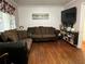 Comfortable living room featuring hardwood floors, couches, and television with bookshelf at 2429 S Laurel Ave, Sanford, FL 32771