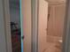 Bathroom featuring tub with shower curtain and a toilet, through double doors from bedroom with desk at 25210 Northlake Dr # 210, Sanford, FL 32773