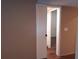View of bathroom with white shower curtain and wood-look flooring through an interior doorway, door open at 25210 Northlake Dr # 210, Sanford, FL 32773