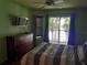 Bright bedroom featuring ceiling fan, balcony access with great view, dresser and wall-mounted TV at 25210 Northlake Dr # 210, Sanford, FL 32773